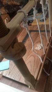 The sewing frame with the cords attached at the crossbar and a pile of wooden keys.